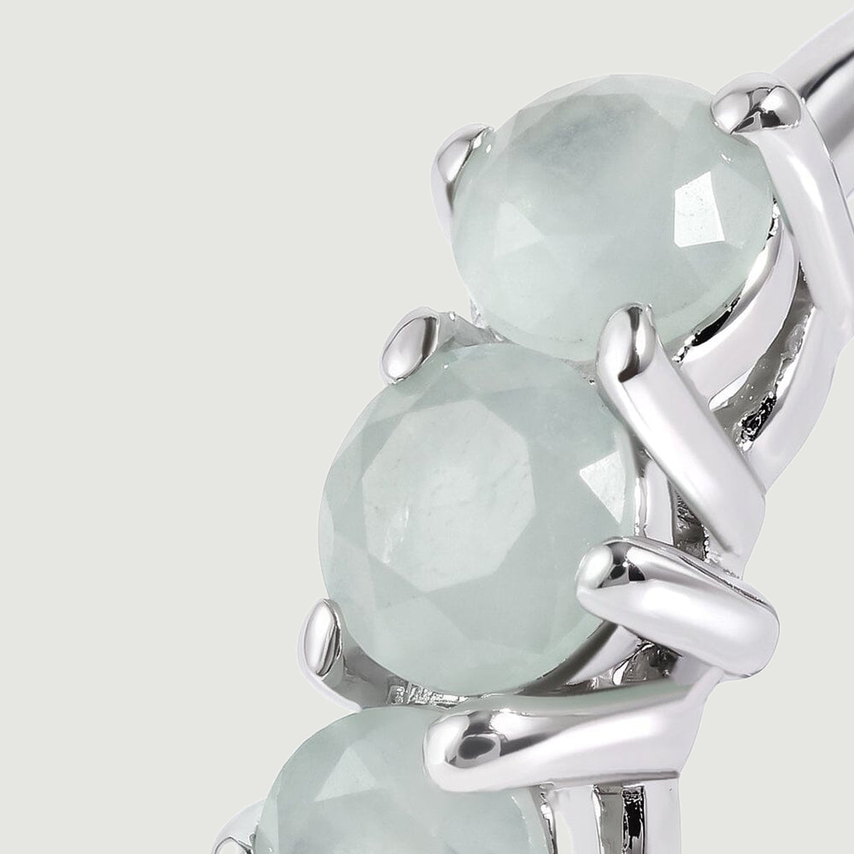 A close view shows pale blue round aquamarines held by polished silver-toned prongs.