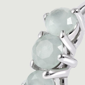 A close view shows pale blue round aquamarines held by polished silver-toned prongs.