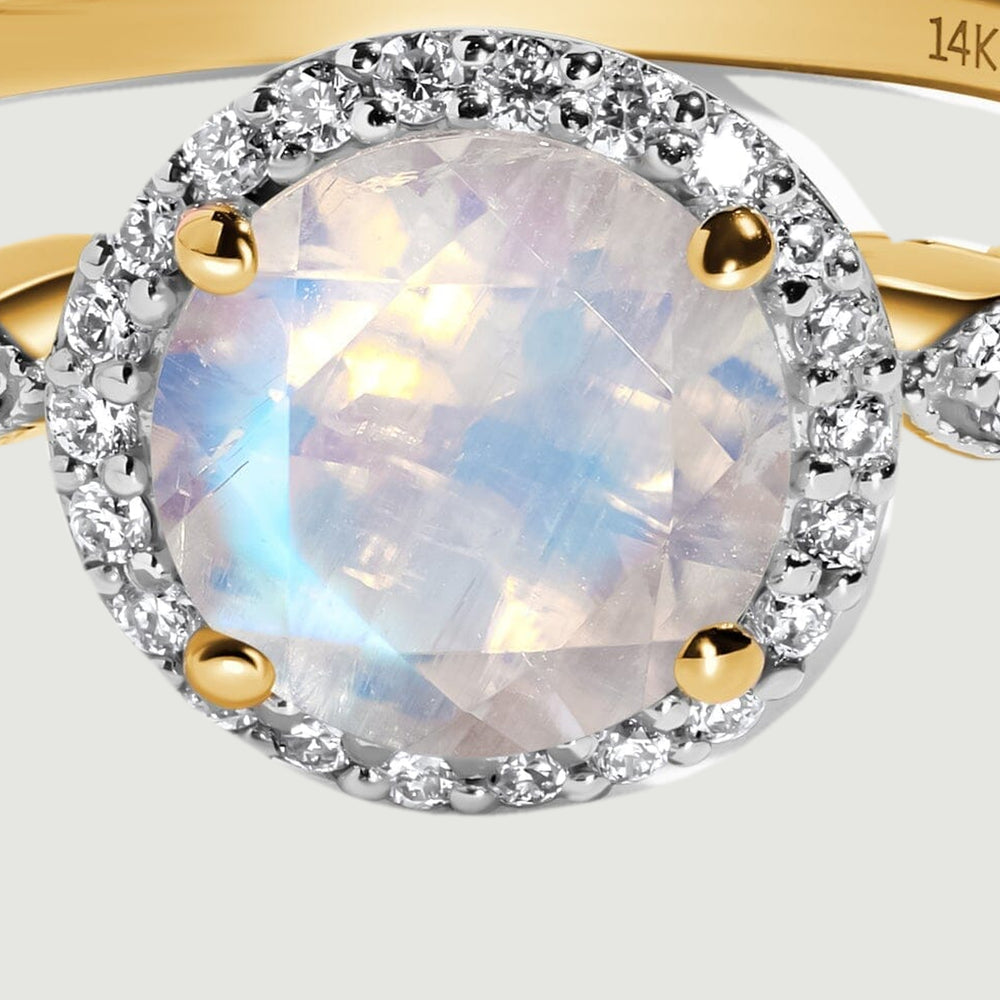 The faceted moonstone is held by four yellow gold prongs inside a circular diamond halo.