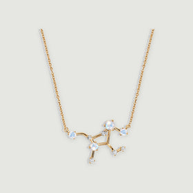 A yellow gold necklace displays round moonstones and small clear stones along an angular pendant on light grey.
