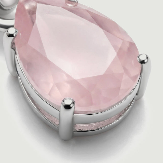 The lower side of the silver pendant reveals its open basket setting and rounded prongs around the pink stone.