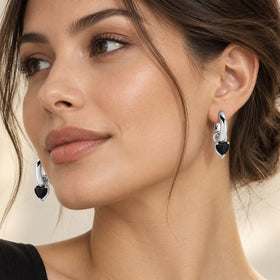 Model's ear wearing a rhodium-plated hoop with a heart-shaped black obsidian drop