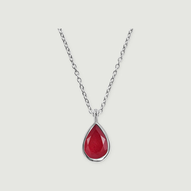 A silver cable chain meets a polished bezel around a faceted pink teardrop stone on light gray.