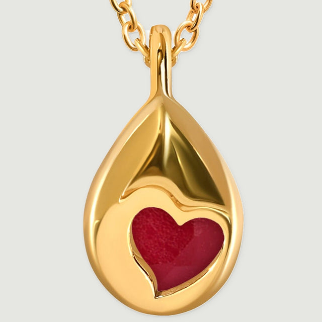 A close view of the yellow gold pendant back shows a heart-shaped opening over the pink stone.