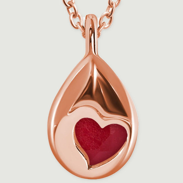 A rose gold pendant back and bail are shown close up with a heart-shaped opening at the center.