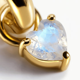 Yellow-gold-tone prongs frame the faceted heart-shaped moonstone beneath a polished hoop.