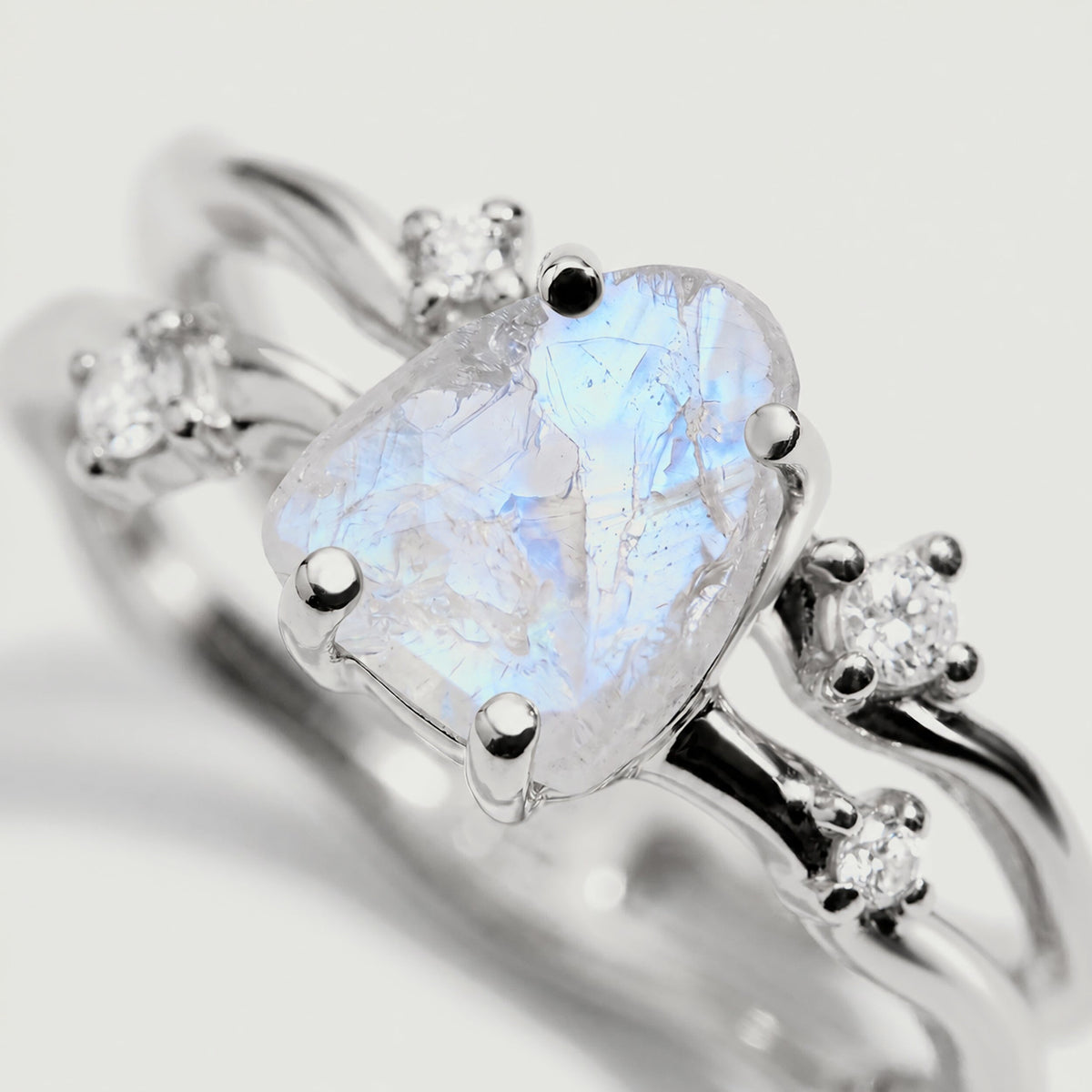 A close view shows blue reflections and natural fissures inside the moonstone held by white gold prongs.