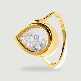 A side view shows a yellow gold band curving behind a clear chamber of blue and white gems.