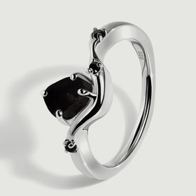 An angled view shows the silver band, raised black center stone and small black accent stones.