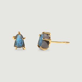 A pair of yellow gold-colored labradorite studs displays rough blue-gray stones and an exposed post against a pale gray background.