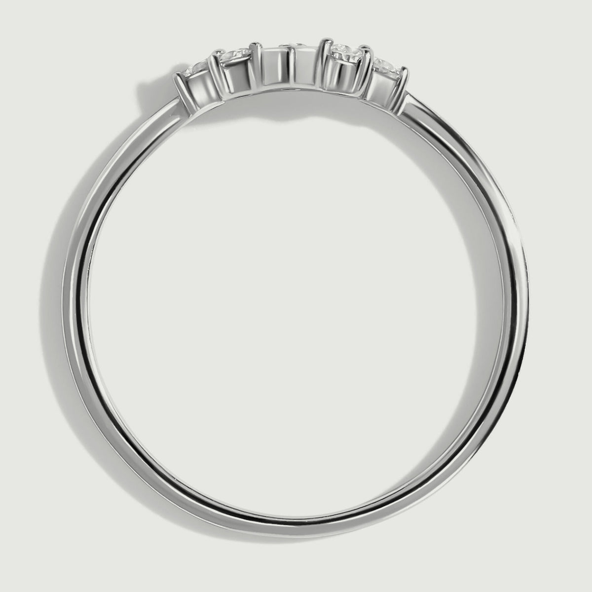 The white gold ring is shown from the side with raised settings above its slim circular band.
