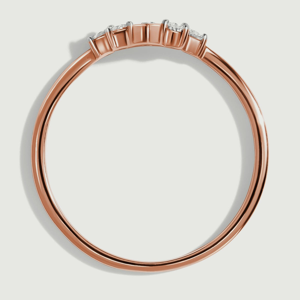 A side view of the rose gold ring shows the open band and the height of its diamond settings.