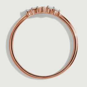 A side view of the rose gold ring shows the open band and the height of its diamond settings.
