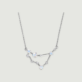 A white gold chain holds an angular pendant with four iridescent round moonstones and small clear stones.