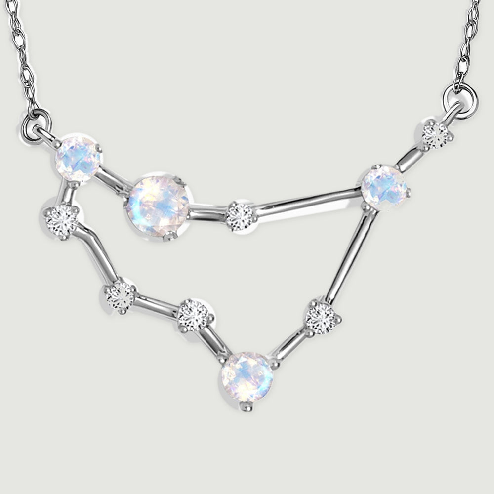 The complete angular pendant rests on a pale gray surface with its two chain attachment loops visible.