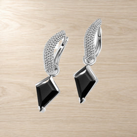 Kite-cut black obsidian hoops lying side by side on a light background