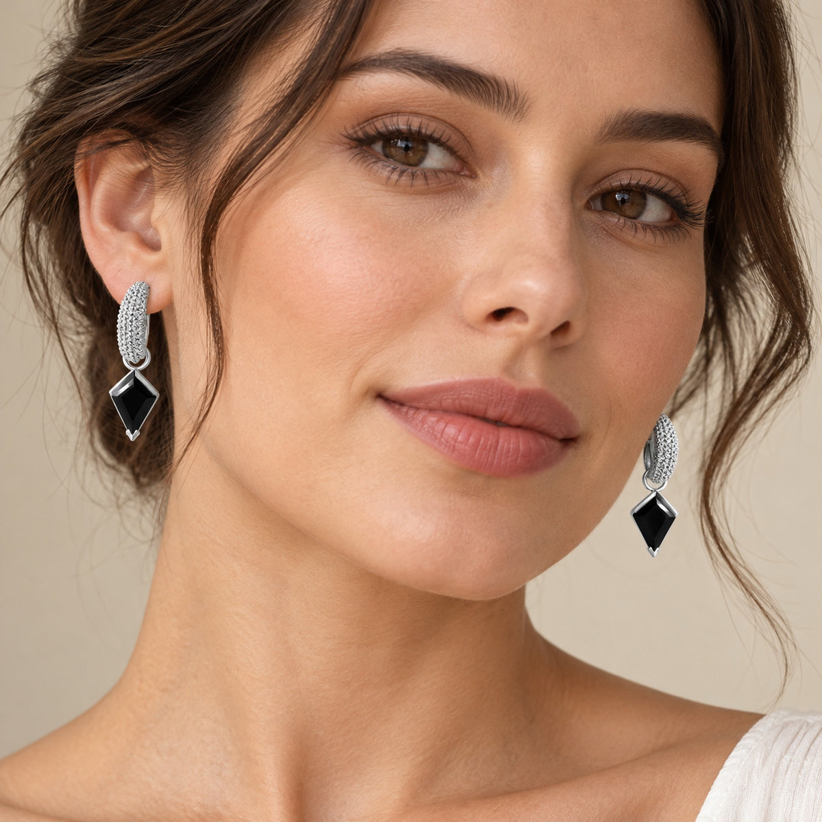 Pair of kite-cut hoops with black obsidian drops, shown on a model in soft daylight