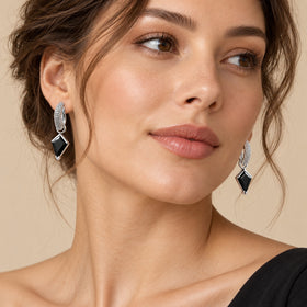 Model wearing kite-cut black obsidian hoop earrings, three-quarter view