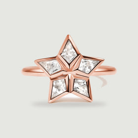 A rose gold ring has five kite-shaped clear stones arranged around an open star center.