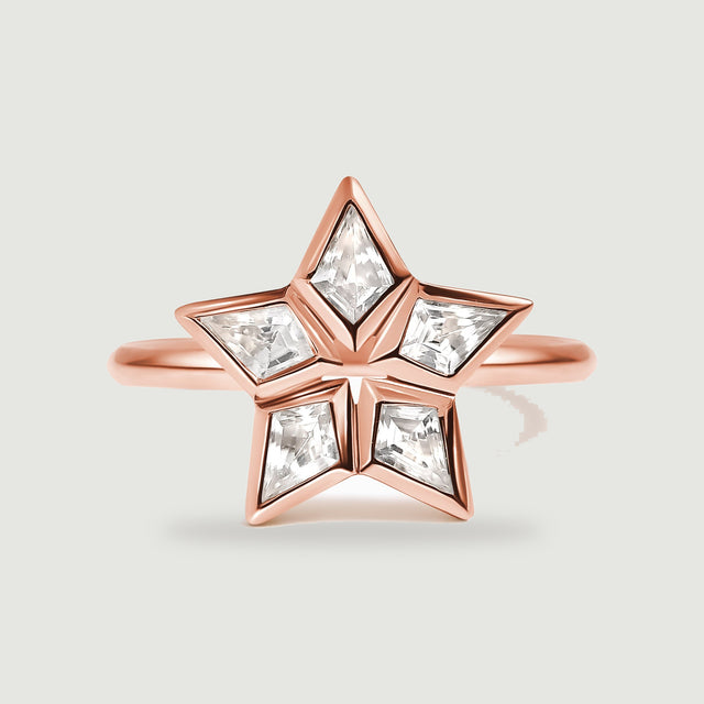 A rose gold ring has five kite-shaped clear stones arranged around an open star center.