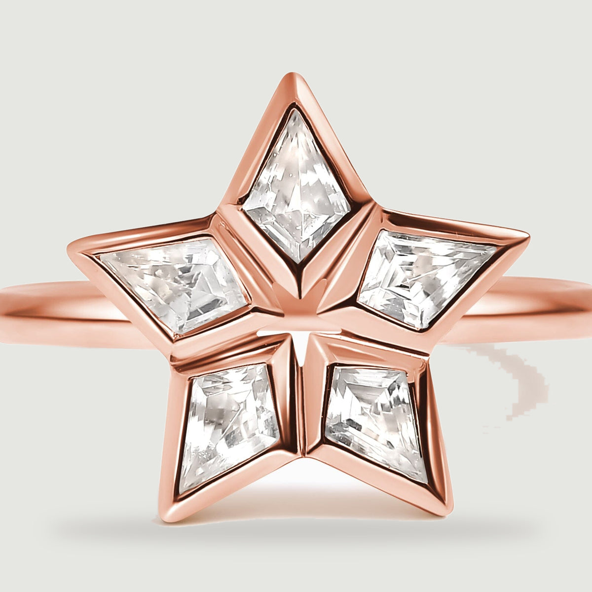 A close view shows the clear faceted stones and polished rose gold edges around the open center.