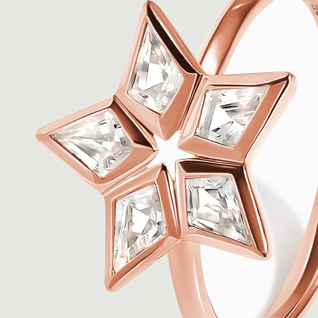 The raised rose gold bezels and pointed clear stones are visible in an angled close-up.