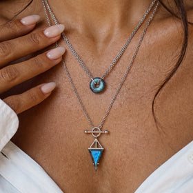 Triangle labradorite pendant worn at the neck with a white top
