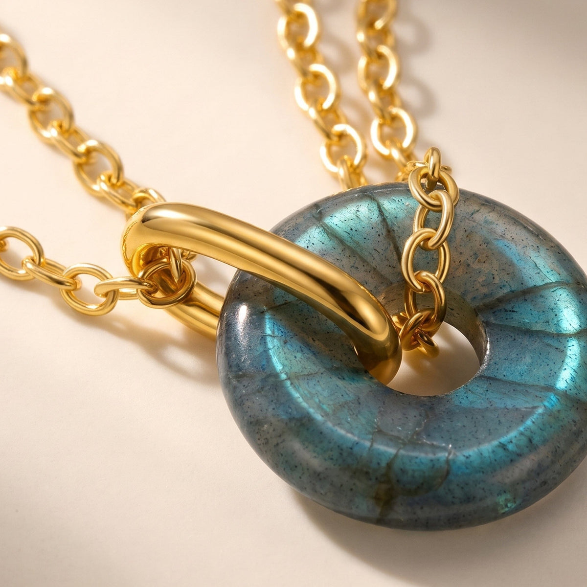 Labradorite donut pendant on a gold chain, close-up