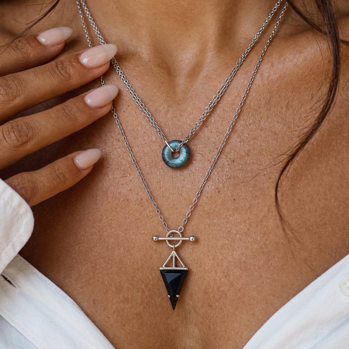 Labradorite pendant on a silver chain worn at the neck with a white top