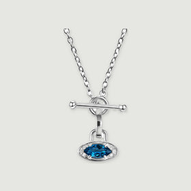 A silver necklace with an oval blue gemstone, clear accent stones and a bar clasp is centered on a light gray background.
