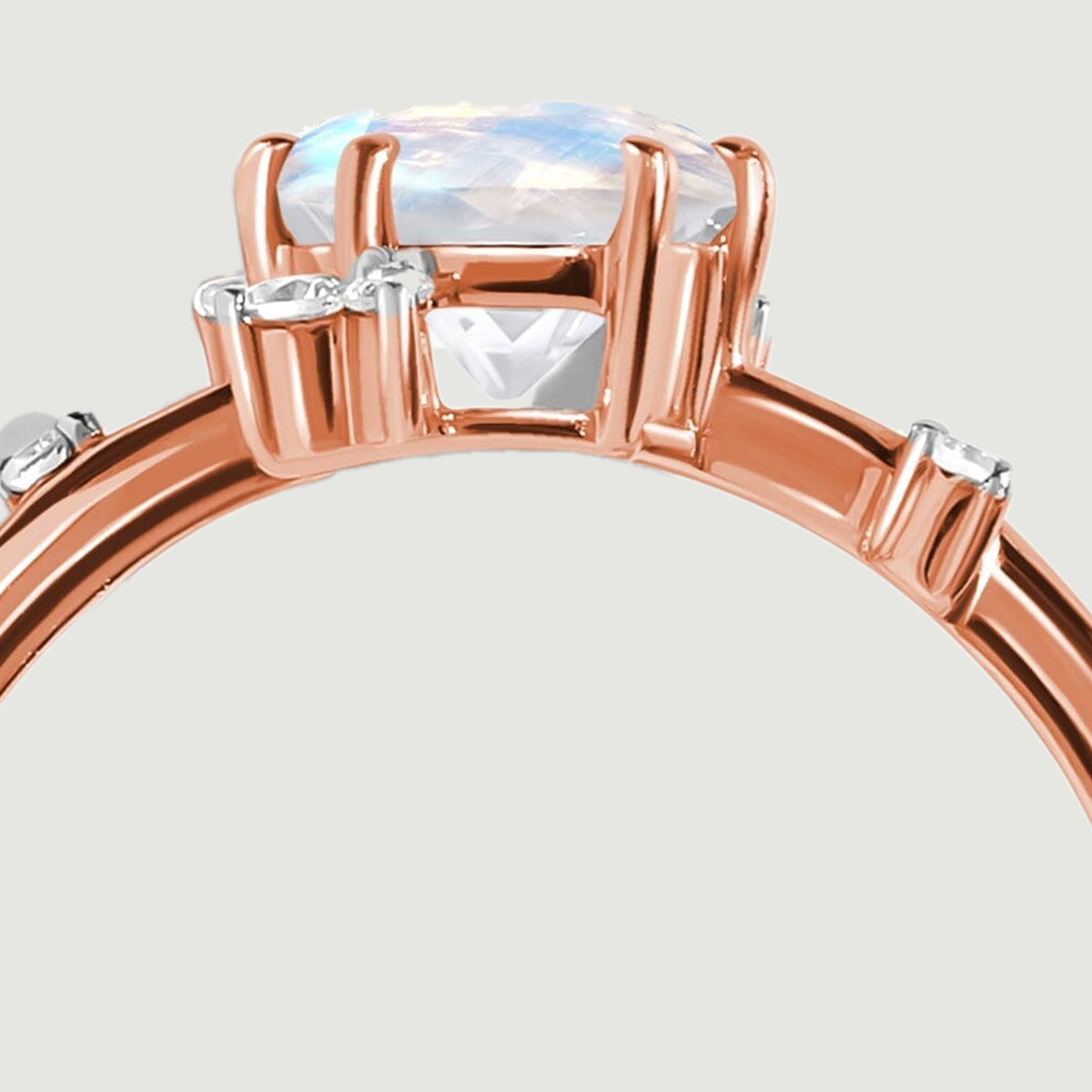 The raised moonstone setting is shown close up with open supports and small diamond settings.
