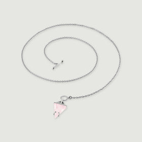 The silver necklace forms a loose coil with its pointed pink pendant resting below the open circular clasp.