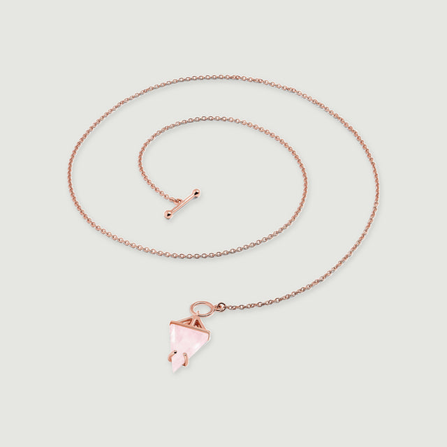 The rose gold chain curves above a pale pink pendant with an angular open setting and rounded prongs.