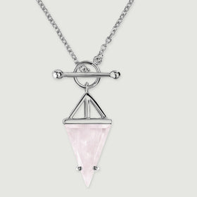 A close view shows the silver circular clasp, ball-ended crossbar and pointed rose quartz beneath an open triangular frame.
