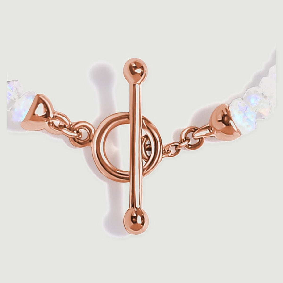The polished rose gold bar, circular clasp and small connecting links are shown in close detail.