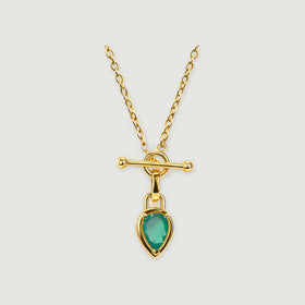 A yellow gold plated necklace has a pear-shaped green stone suspended below a polished bar and circular clasp.