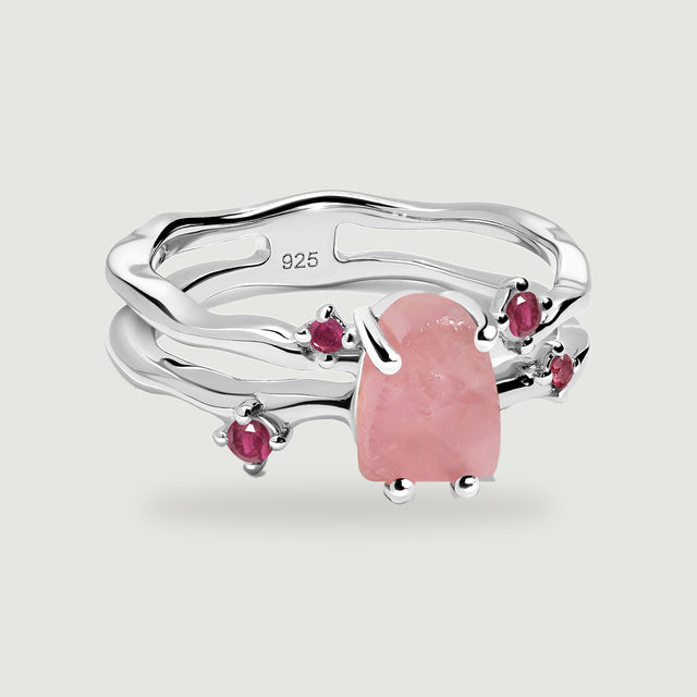 A sterling silver ring presents a raw pink rose quartz center, four ruby accents, and a visible 925 stamp.
