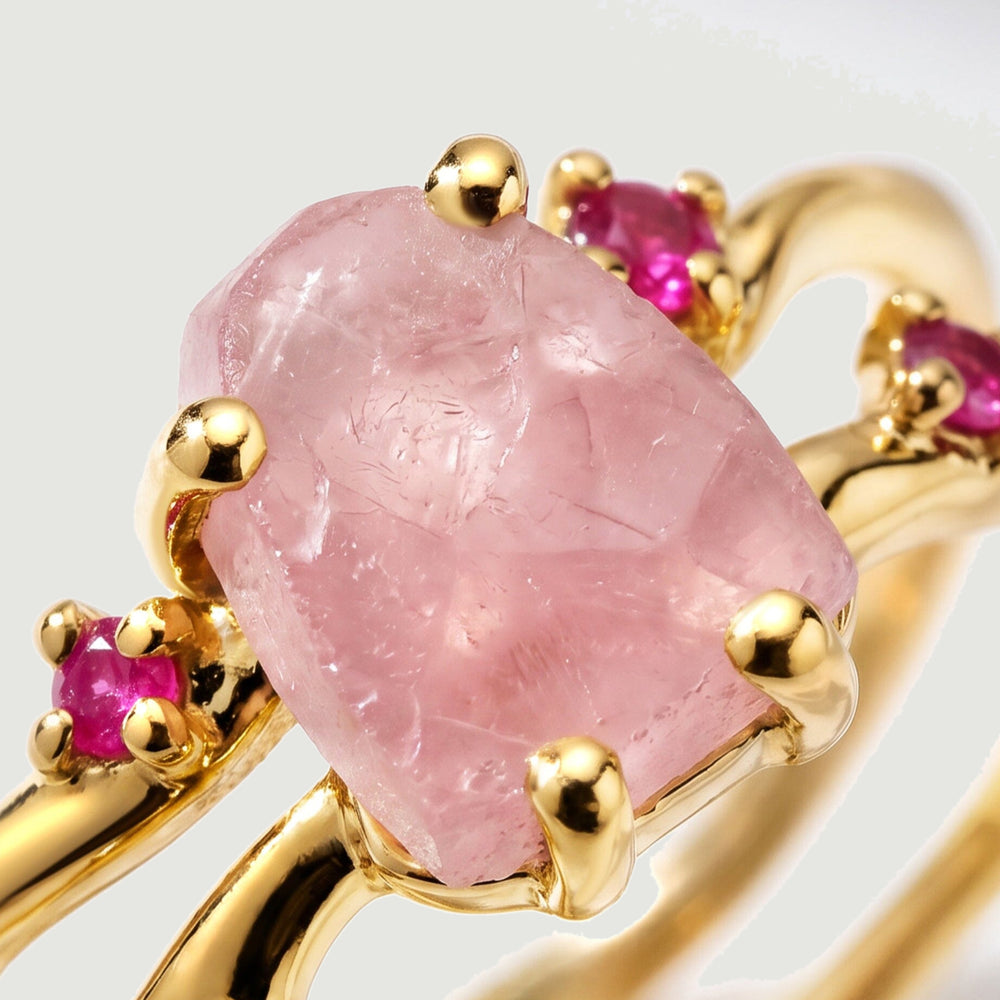 A close view shows the raw texture of pink rose quartz and ruby settings held by yellow gold vermeil prongs.