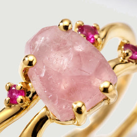 A close view shows the raw texture of pink rose quartz and ruby settings held by yellow gold vermeil prongs.
