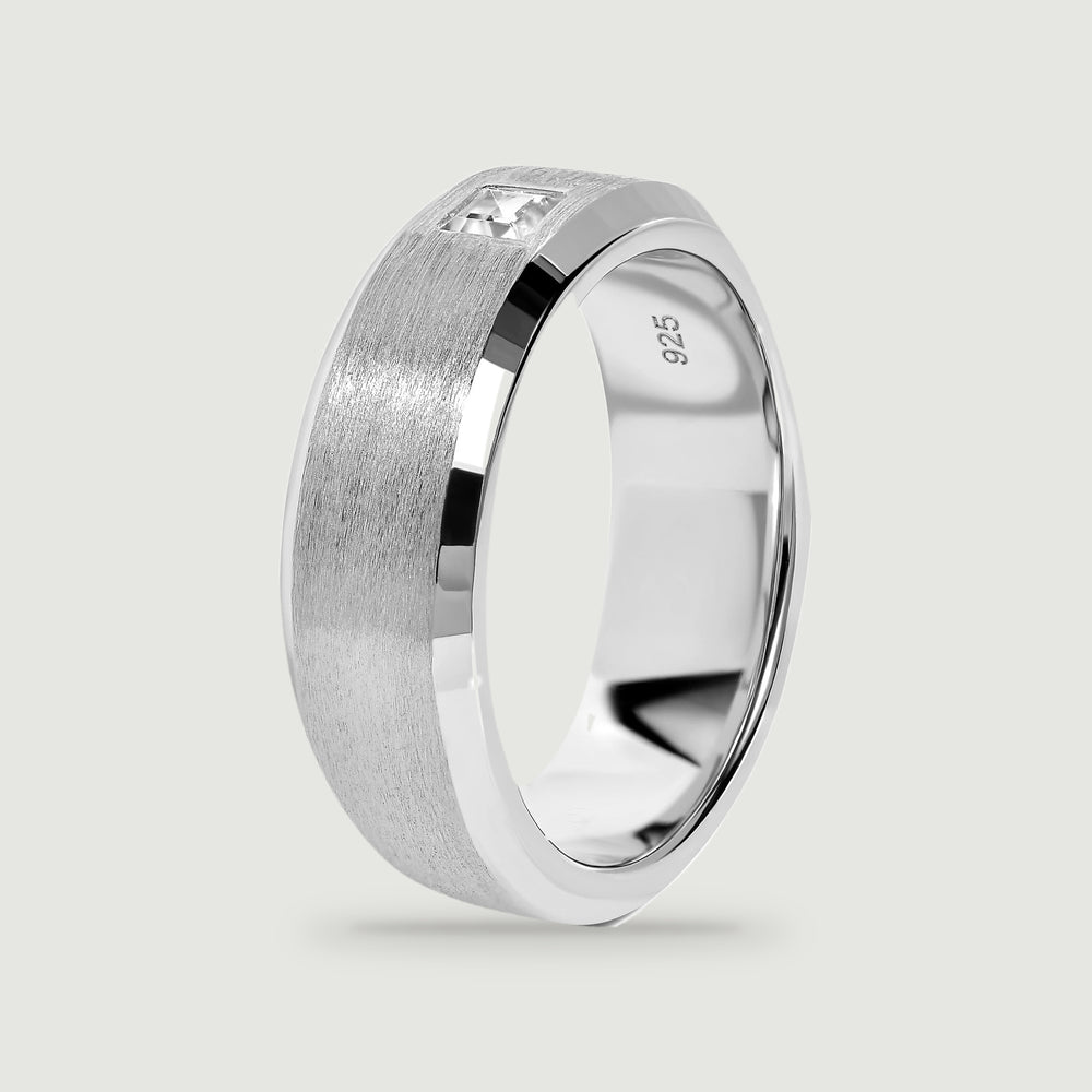 An upright silver ring reveals its polished inner surface and brushed outer band.