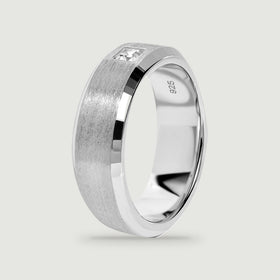 An upright silver ring reveals its polished inner surface and brushed outer band.