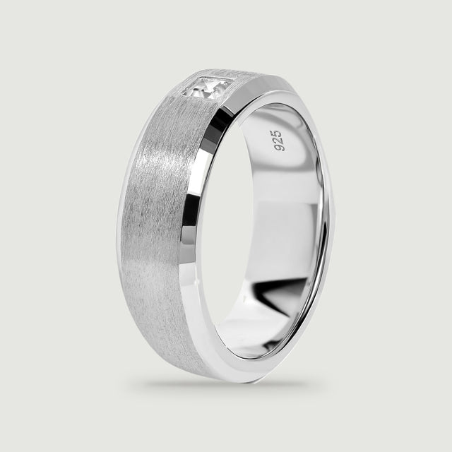 An upright silver ring reveals its polished inner surface and brushed outer band.
