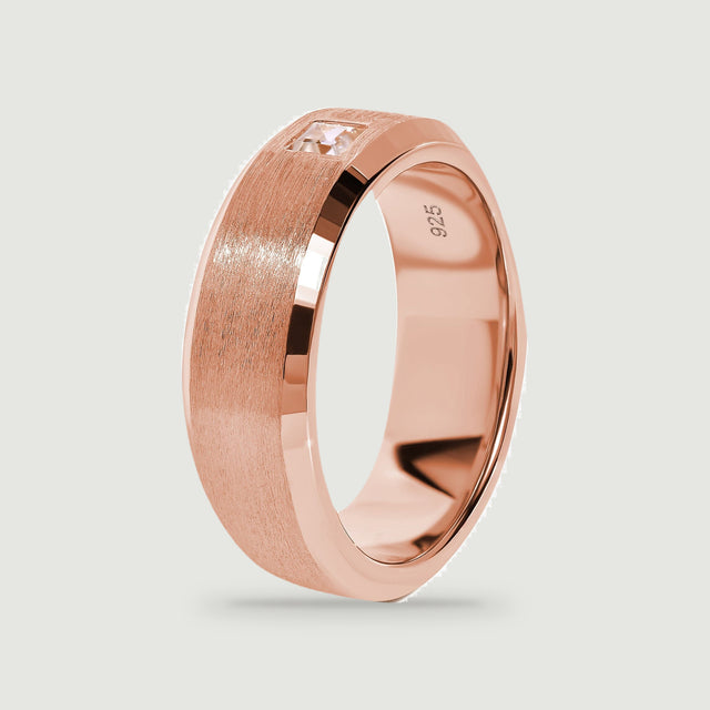 An angled rose gold ring shows its smooth inner curve and satin exterior.