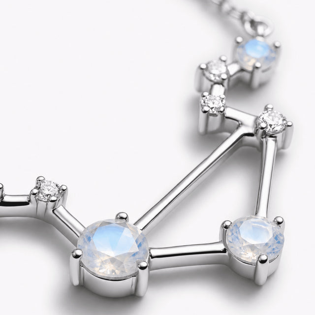 A close view shows blue moonstone facets, clear stones, and polished silver prong settings.