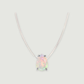A pear-shaped opal with four silver prongs hangs from a transparent cord against a light gray background.