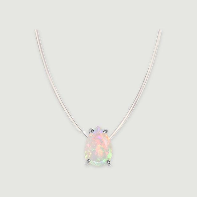A pear-shaped opal with four silver prongs hangs from a transparent cord against a light gray background.