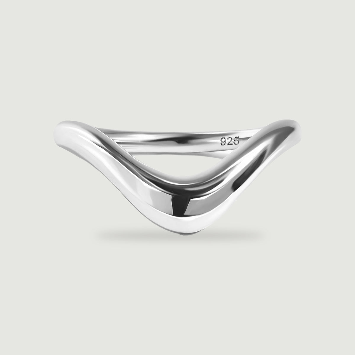 A smooth silver V-shaped ring is shown from the front with a soft contact shadow.
