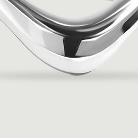 The silver ring has a broad curved front with bright reflections along its edges.
