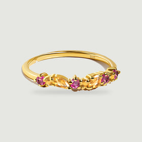 A yellow gold vermeil ring with orange citrine and round pink topaz rests on a pale gray background.