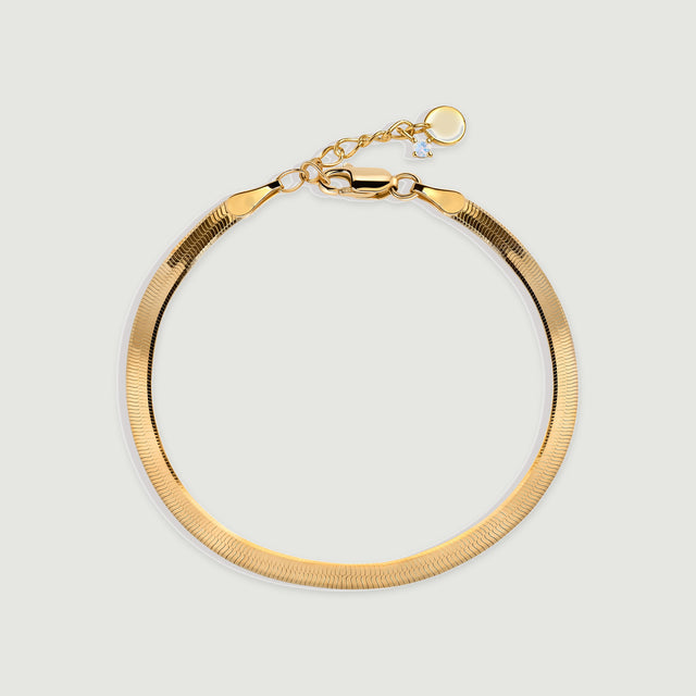 A yellow gold herringbone bracelet rests in a rounded loop with a lobster clasp at the top.